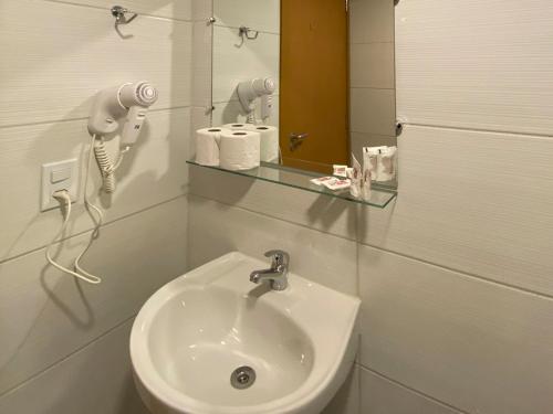 Baño blanco con lavabo y espejo en P1 Hotel en Santa Maria