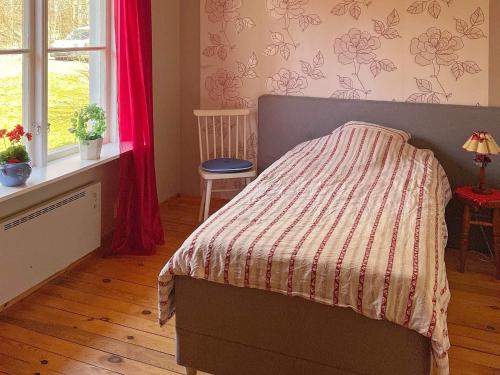 Un dormitorio con una cama con una manta. en Holiday home ASKERSUND, en Askersund