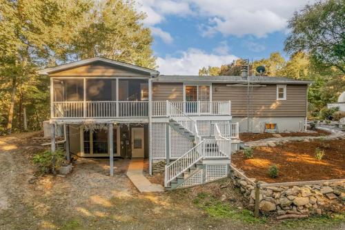 ein Haus mit einer großen Veranda und einer Treppe zu einem Haus in der Unterkunft 40 Acres w/Waterfalls, Vineyard, Stream, 5 bedroom in Moravian Falls