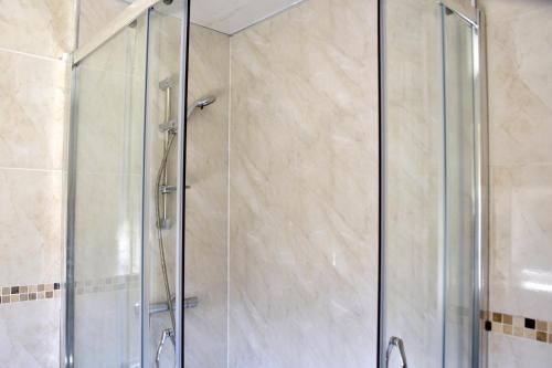 a shower with a glass door in a bathroom at Lindrick Villa- 3BD Bunglow , Free parking- Long stays in Leicester