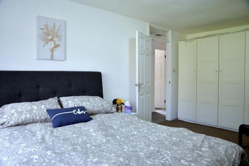 ein Schlafzimmer mit einem Bett mit einem blauen Kissen darauf in der Unterkunft Lindrick Villa- 3BD Bunglow , Free parking- Long stays in Leicester