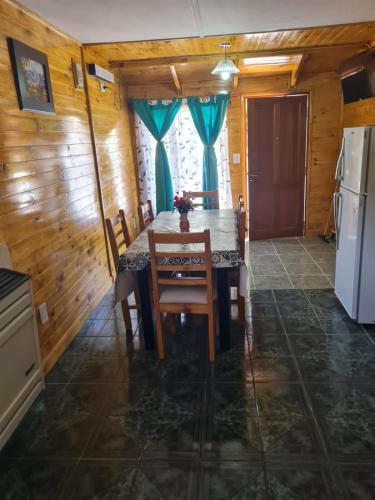 a dining room with a table and a refrigerator at Doña juanita in Los Antiguos