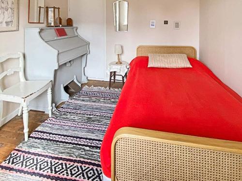 ein Schlafzimmer mit einem Bett mit einer roten Decke in der Unterkunft Holiday home Ljungbyhed III in Ljungbyhed
