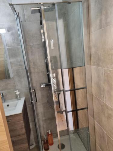 une douche avec une porte vitrée à côté d'un lavabo dans l'établissement Charmant studio neuf 150m plage sur avenue principale climatisé et parking, à Cavalaire-sur-Mer