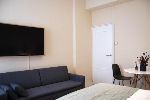 a living room with a couch and a tv on the wall at Apartamentos Centro in Albacete