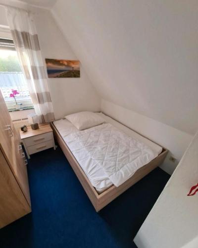 a small bedroom with a bed and a window at Monteurs-Ferienwohnung in Emden