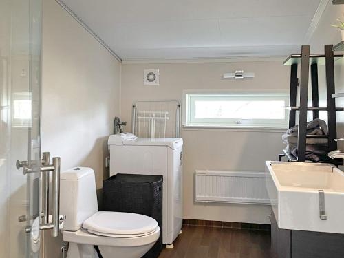 uma casa de banho com um WC branco e um lavatório. em Holiday home STENUNGSUND II em Stenungsund