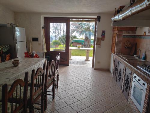 una cucina con tavolo, sedie e frigorifero di La Pergola a Ischia
