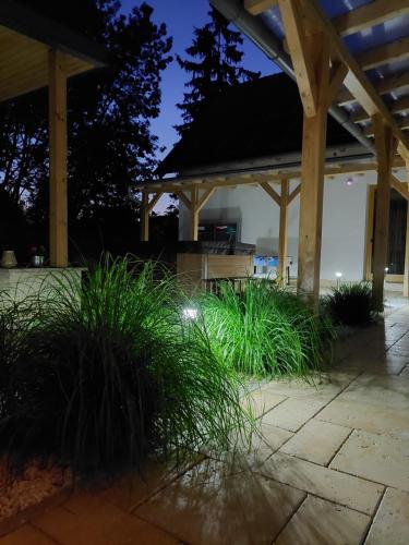 a pavilion with grass and a bench at night at Villa Quality Wellness in Dozmat