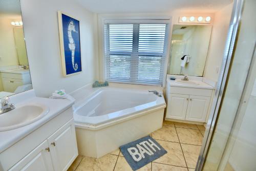 a white bathroom with a tub and a sink at Caribbean 404 in Gulf Shores