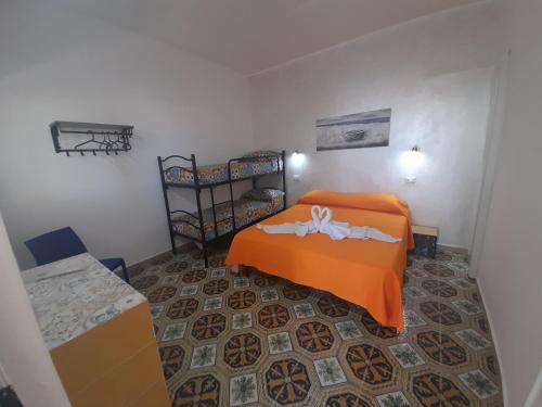 sypialnia z pomarańczowym łóżkiem w pokoju w obiekcie Vulcano: La Porta Delle Eolie w mieście Vulcano