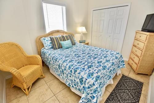a bedroom with a bed and a chair and a television at Caribbean 404 in Gulf Shores