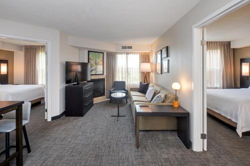 ウィットビーにあるResidence Inn by Marriott Whitbyのベッド2台とソファが備わるホテルルームです。