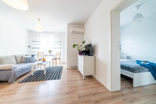 a bedroom and living room with a bed and a couch at Apartament Graniczna 6B in Bydgoszcz