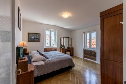 1 dormitorio con 1 cama y 2 ventanas en The Heart of Palace Apartment, en Split