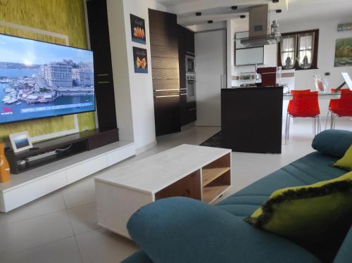 un soggiorno con divano blu e grande TV di CA' VERDEMARE a Varazze