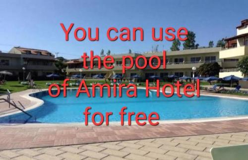 comfy center rodos - sweethome في Asgourou: لوحة تدل على أنه يمكنك استخدام مسبح فندق أمينا مجانًا