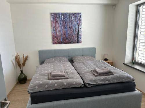 a bed in a bedroom with a painting on the wall at Apartment Rosarian in Hrubá Borša