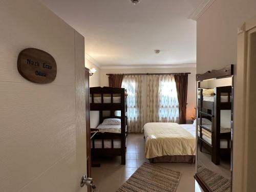 a room with a bed and bunk beds in it at Cunda Alibeyhan Otel in Cunda