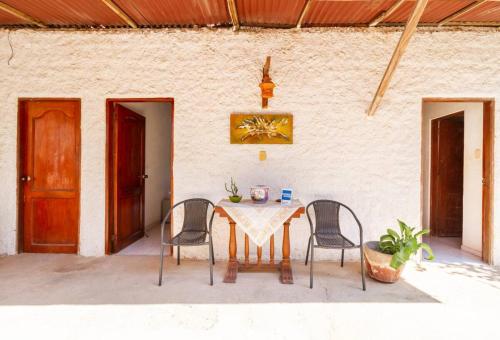a table and chairs in a patio with a wall at Casa Tara in Taganga