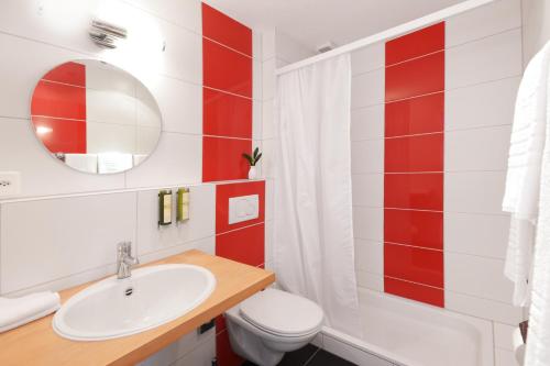 ein Badezimmer mit einem Waschbecken, einem WC und einem Spiegel in der Unterkunft Hotel & Restaurant Nollen in Hosenruck
