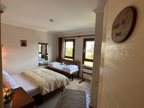 a bedroom with two beds and a clock on the wall at Cunda Alibeyhan Otel in Cunda
