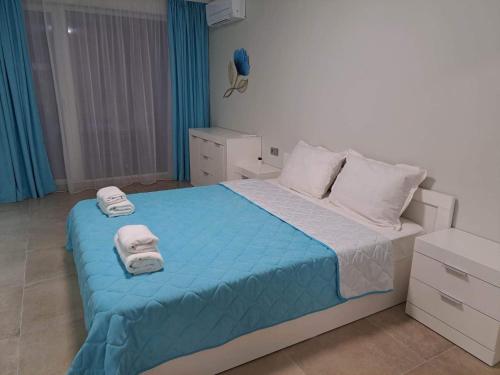a bedroom with a bed with towels on it at ATEA APARTMENT KAVARNA in Kavarna