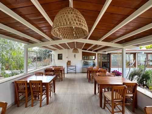 a restaurant with wooden tables and chairs and a large ceiling at Cunda Alibeyhan Otel in Cunda