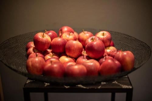 a bowl of red apples on a table at Vitalpina Hotel Waldhof in Rablà