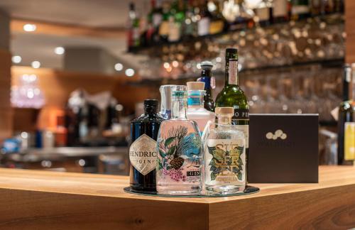 a couple of bottles of alcohol sitting on a bar at Vitalpina Hotel Waldhof in Rablà