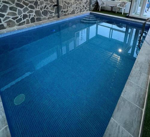 馬拉加的住宿－Casa Rural El Castillo，一座铺有蓝色瓷砖地板的大型游泳池