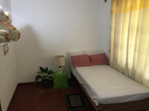 een kleine slaapkamer met een bed en een lamp bij Menara Villa in Kamburugamuwa