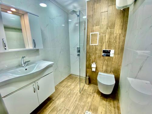 a bathroom with a toilet and a sink and a shower at M&M Center Apartment with free parking in Plovdiv