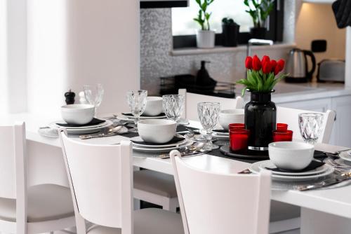 a white table with red tulips in a black vase at Villa Concha Con Perla in Monolithos