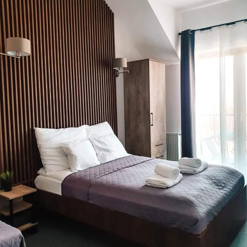 a bedroom with a bed with two towels on it at Willa Zdrojowa in Polańczyk
