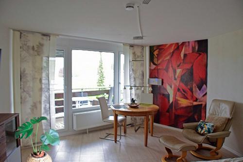 a living room with a table and a large window at Rosenalm - Appartement 30 in Scheidegg