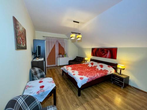 a bedroom with a bed with a red comforter at Red Rose in Władysławowo