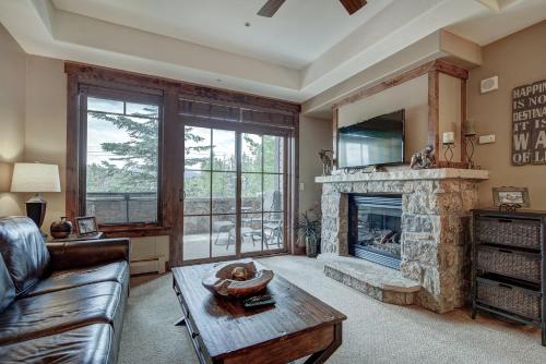 a living room with a stone fireplace and a couch at Crystal Peak Lodge By Vail Resorts in Breckenridge