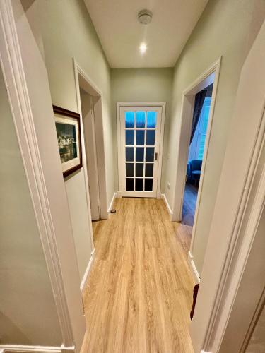 a hallway of a home with wood floors at The Blue Door in Kirkcudbright