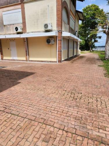 a brick road in front of a building at Hello-Guyane, Marina 2, Studio Prestige 5 étoiles in Saint-Laurent du Maroni