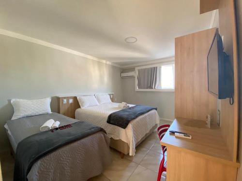 um quarto com 2 camas e uma televisão de ecrã plano em P1 Hotel em Santa Maria