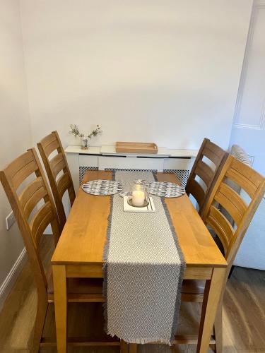 a dining room table with a candle and chairs at The Blue Door in Kirkcudbright