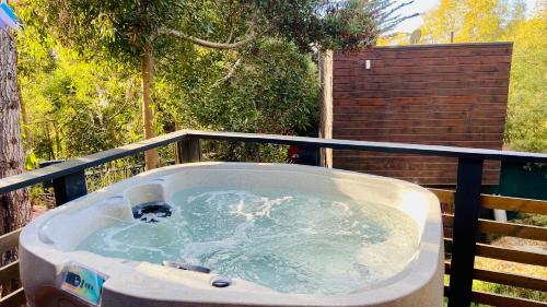a jacuzzi tub on top of a balcony at Cabaña del Bosque in Pichilemu