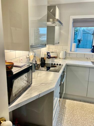 a kitchen with white counter tops and a window at The Blue Door in Kirkcudbright