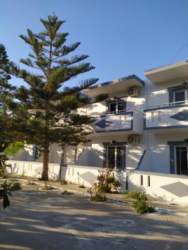 a building with a tree in front of it at Dionisia apartments 8 in Kos