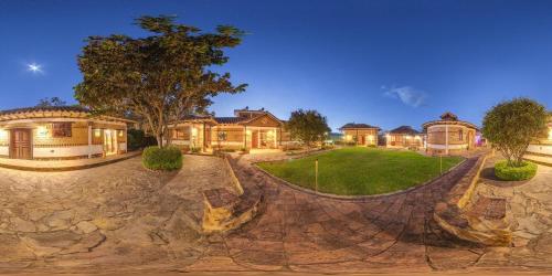 a home with a large yard with a rock wall at Hotel Casa Elemento Villa de Leyva in Villa de Leyva