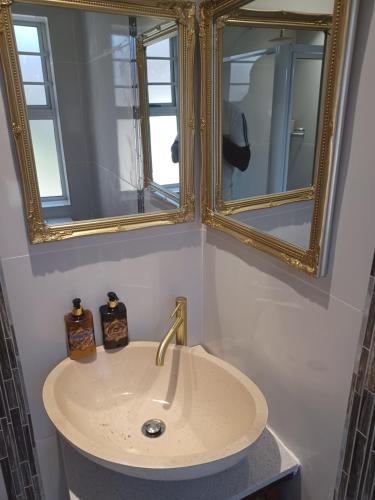 un baño con lavabo y espejo en Summerstrand self catering for two, en Port Elizabeth