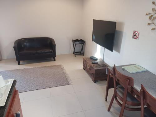 Una sala de estar con un sofá y un televisor. en Summerstrand self catering for two, en Port Elizabeth