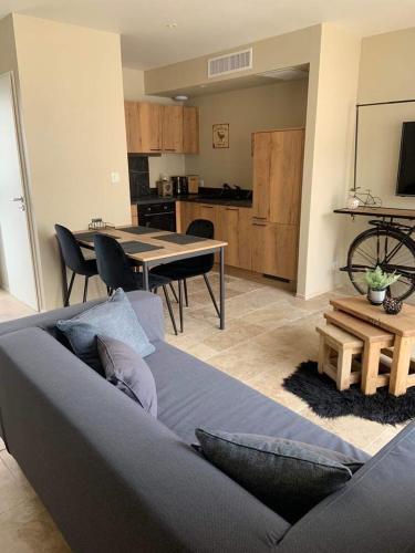 un salon avec un canapé et une table et une cuisine dans l'établissement Le Silence Du Ventoux, à Malaucène