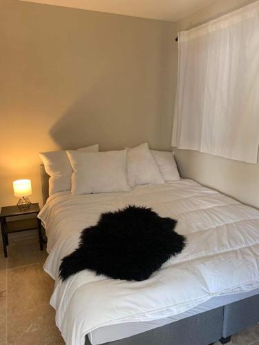 un lit avec un oreiller en fourrure noire dessus dans l'établissement Le Silence Du Ventoux, à Malaucène
